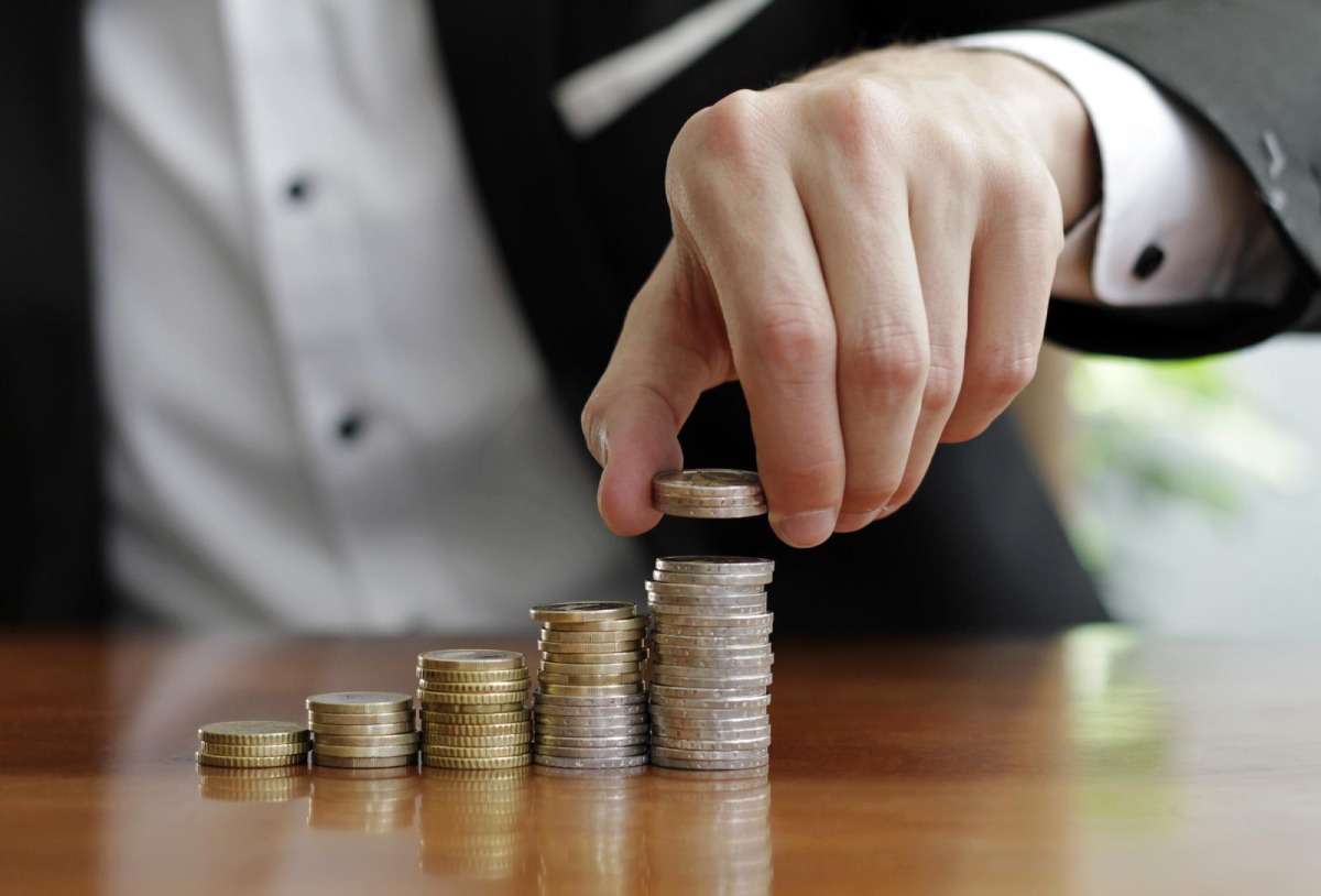 Closeup shot of a businessman's hands counting stacks of coins