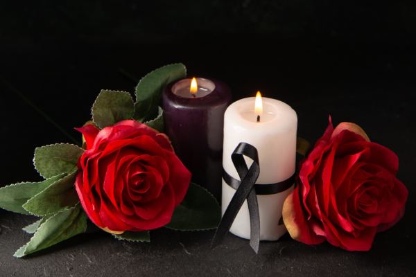 Front view of pair of candles red flowers on black