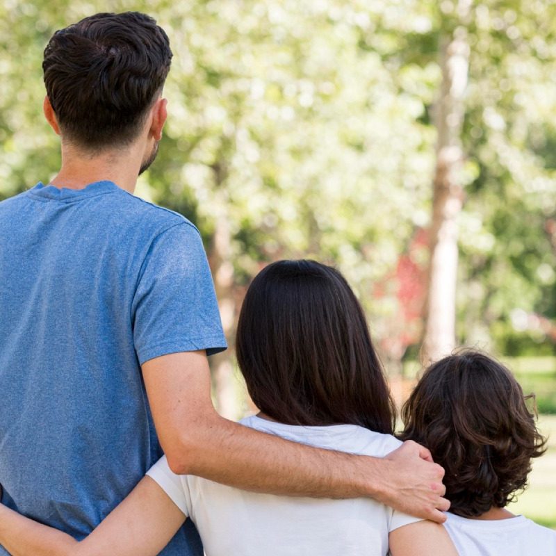 Back view of family with parents and child embraced